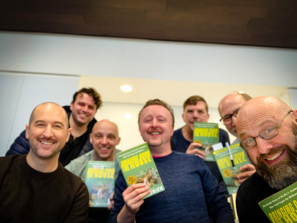 Book club men holding up copies of "Bringing Down The House" by Ben Mezrich